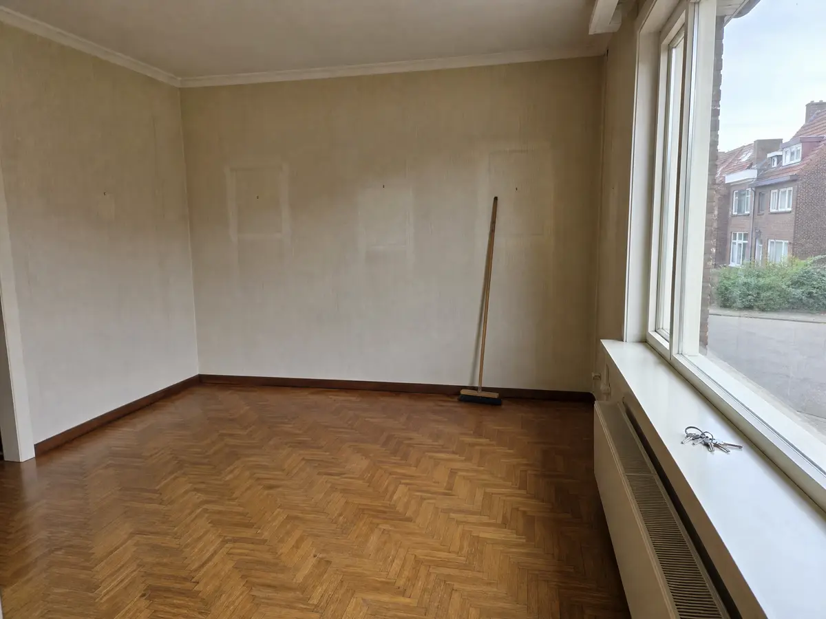 Een lege, geveegde woonkamer met de sleutels op de vensterbank na het leegmaken
