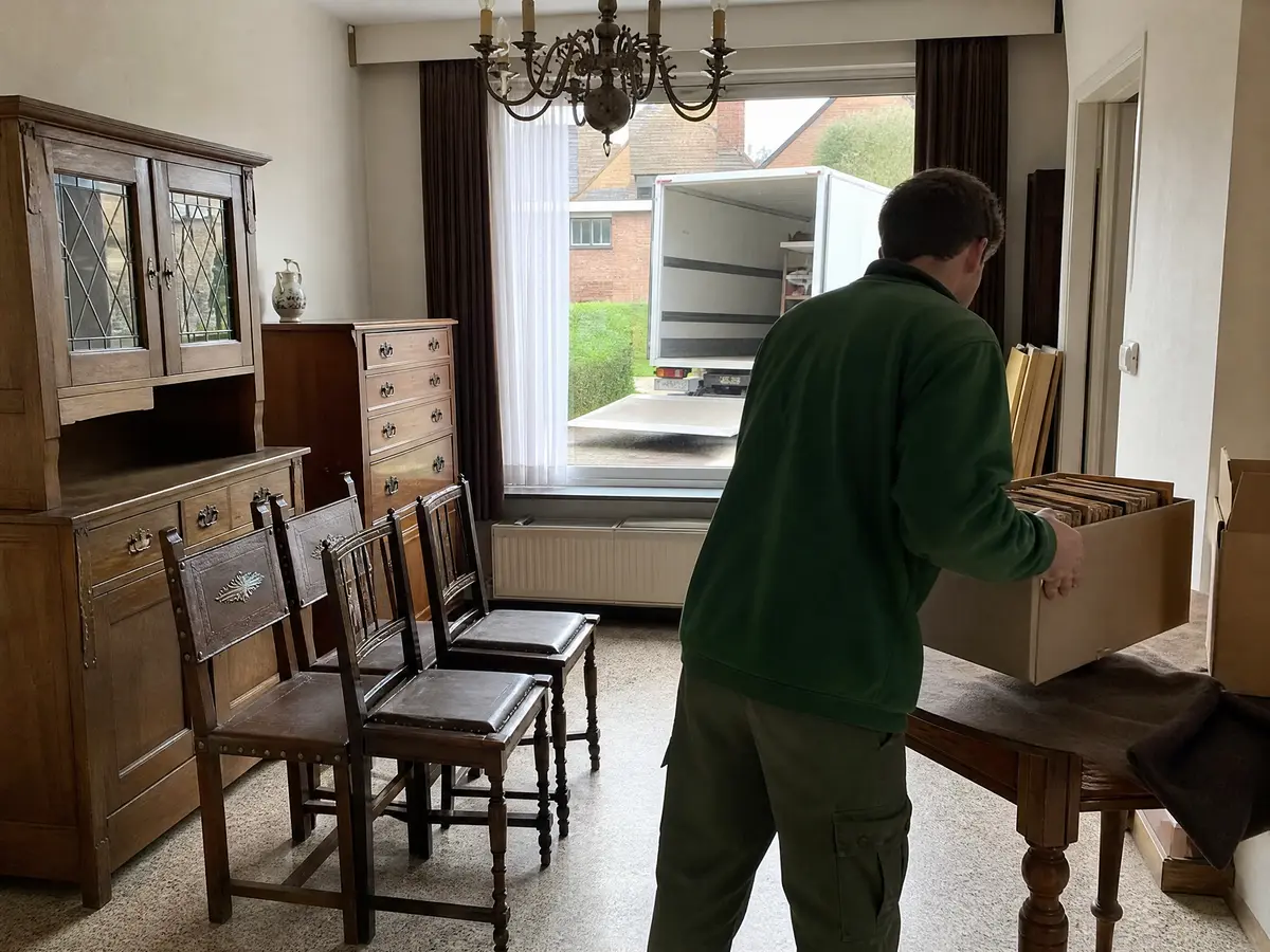 Fotoalbums en brieven apart gelegd in een doos voor de familie tijdens het leegmaken van de inboedel