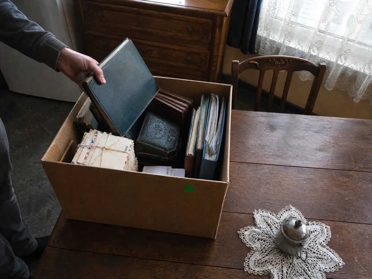 Fotoalbums, brieven en documenten van een overledene apart gelegd in een doos voor de familie